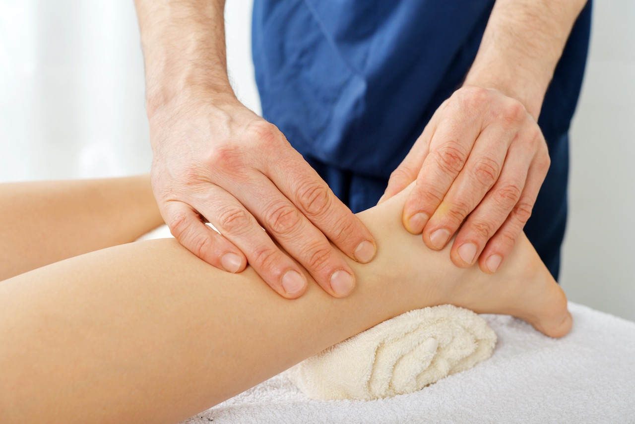 Tui Na Massage Fuss Therapeut behandelt Fuss und Achillessehne mit Tui Na Massage